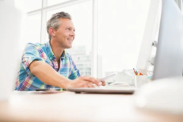 White male working on computer smiling